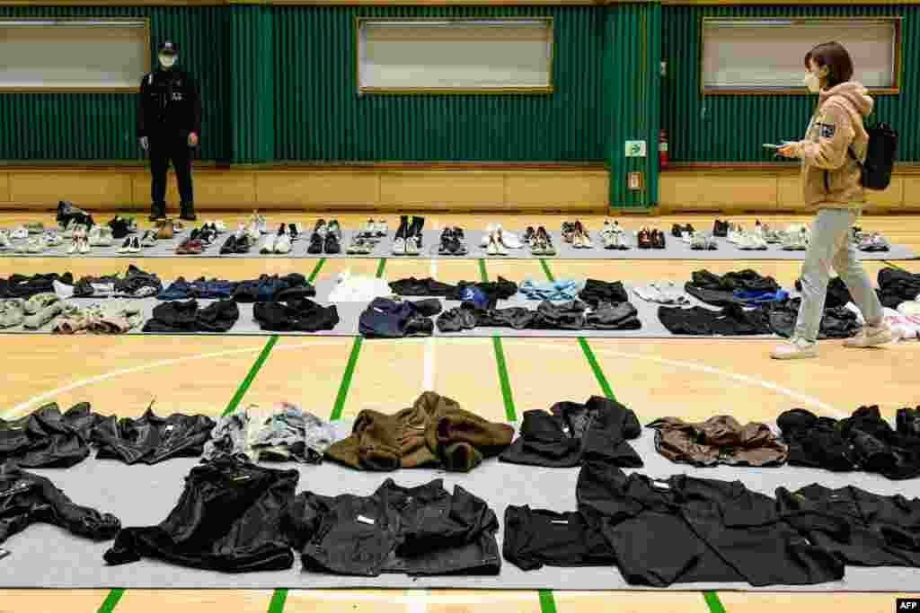 A journalist walks amongst personal belongings retrieved by police from the scene of a fatal Halloween crowd surge that killed more than 150 people in the Itaewon district, at a gymnasium for relatives of victims to collect, in Seoul, South Korea.