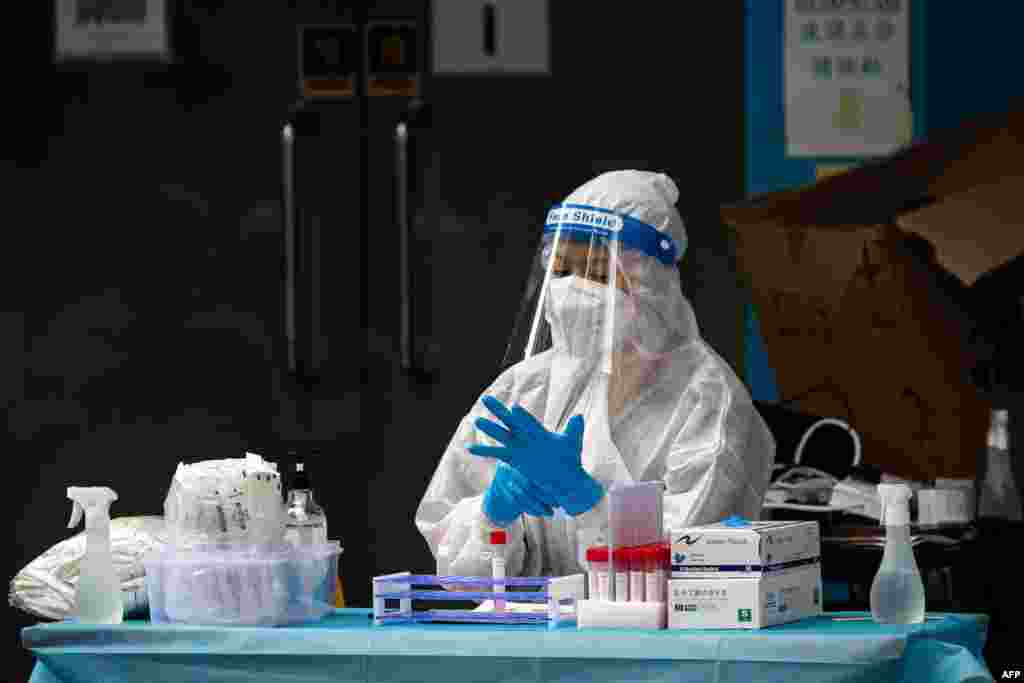 A health worker puts gloves on during COVID-19 tests of the entire population in Macau.