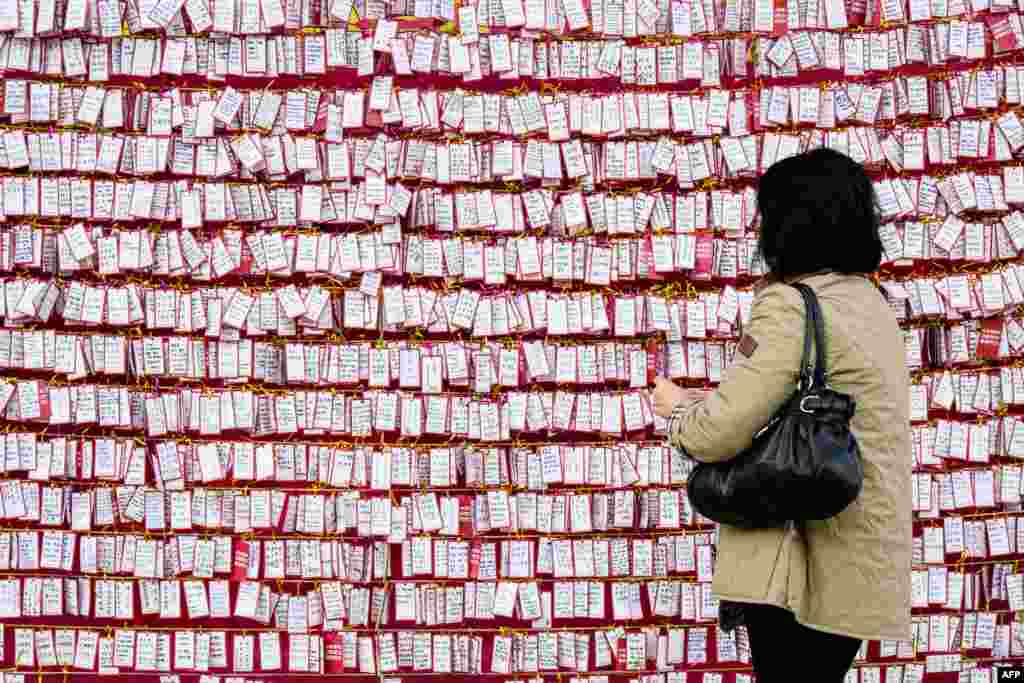 A Buddhist woman places a handwritten note on display as prayers take place at the Jogyesa Buddhist temple for the success of children who at the same time were sitting for the annual nine-hour college entrance exam, locally known as "Suneung," in Seoul, South Korea.