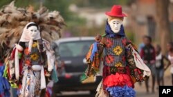 Gule Wamkulu dance secretive society members in gory masks and colorful outfits walk on the streets enroute to their ritual dance performance in Harare, Zimbabwe, Saturday,Oct, 23, 2022.(AP Photo/Tsvangirayi Mukwazhi)
