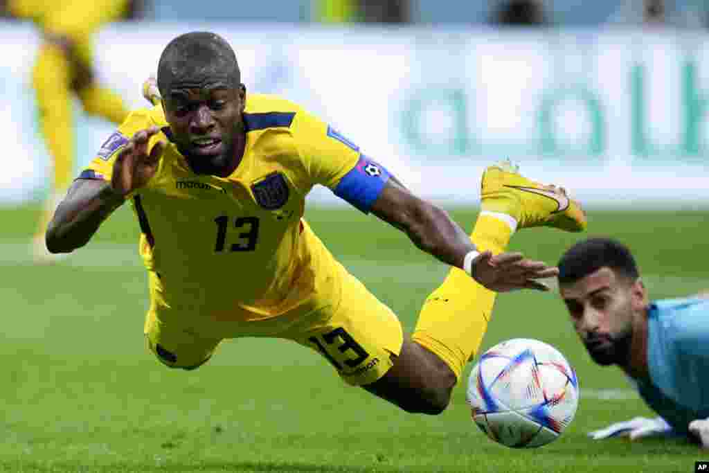 Ecuador's Enner Valencia falls, fouled by Qatar's goalkeeper Saad Al Sheeb, during a World Cup group A soccer match at the Al Bayt Stadium in Al Khor, Qatar.