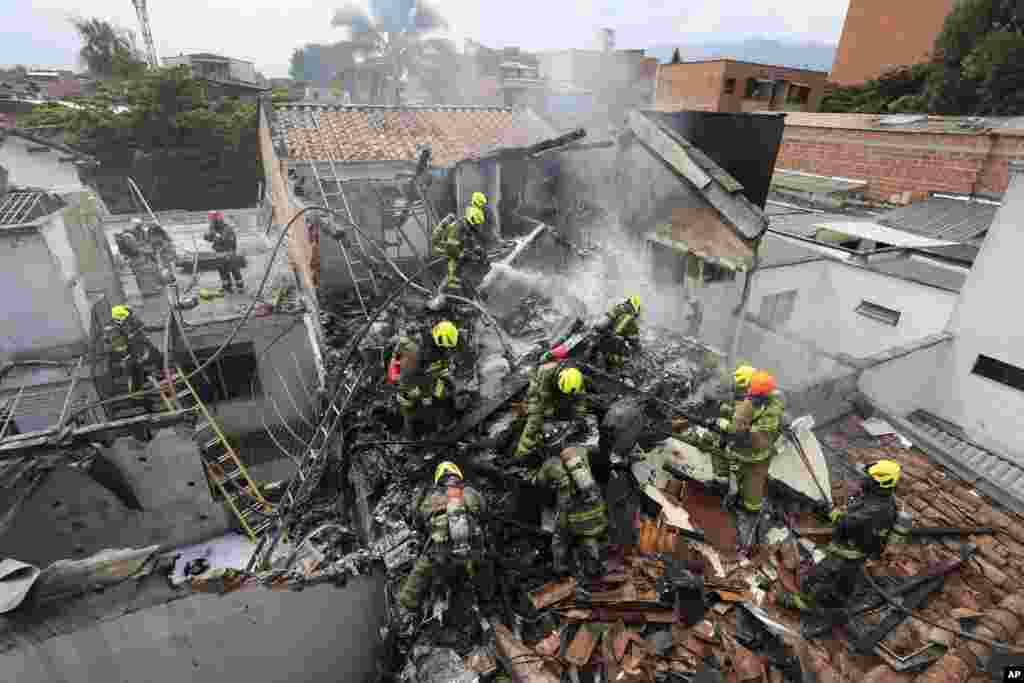 Firefighters work at the crash site of a small plane that fell on top of homes in a residential area of Medellin, Colombia.&nbsp;The plane crashed shortly after taking off from Medellin's Olaya Herrera airport, killing at least eight people including two members of the crew and his six passengers, according to city Mayor Medellin Daniel Quintero.