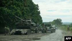 This handout photograph taken Sept. 9, 2022, released Sept. 11, shows Ukrainian soldiers loading an abandoned Russian military vehicle on a trailer during the Ukrainian Army counter-offensive in Kharkiv region. (General Staff of the Ukrainian Armed Forces / AFP)