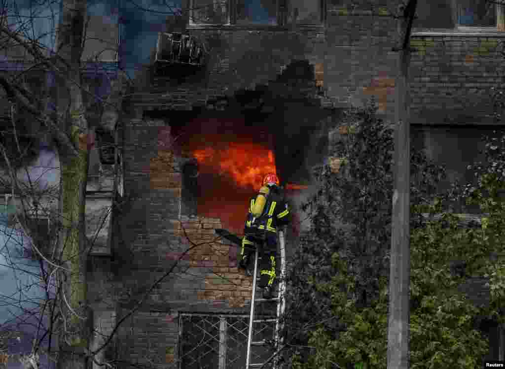 Firefighters put out a fire in a residential building hit by a Russian missile strike in Kyiv, Ukraine.