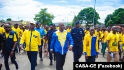 Ao centro, presidente da CASA-CE, Manuel Fernandes, caminha pelas ruas bo bairro Rocha Pinto, em Luanda