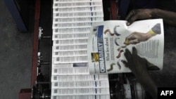 肯尼亞首都內羅畢一家印刷廠的技術人員正在檢查當地中國人擁有的《中國日報》（2014年1月3日）