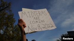 A demonstrator holds a sign reading "Midterms are Coming Nov 8, 2022" during a protest in support of abortion rights in front of the Massachusetts State House in Boston, May 3, 2022.