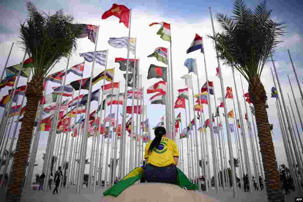 A woman sits at Flags square, in Doha, ahead of the Qatar 2022 World Cup football tournament. 