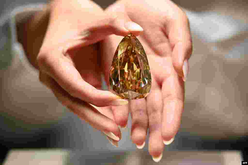 A representative from Sotheby's Hong Kong holds up the Golden Canary diamond in Hong Kong.