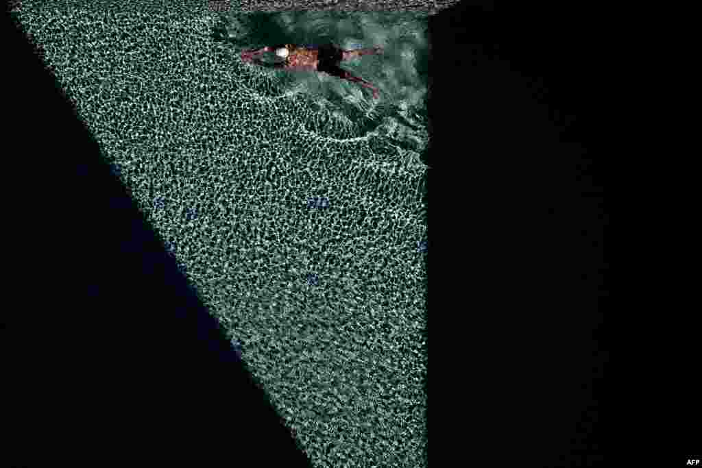 A man swims in a pool at a residential condominium in Bangkok, Thailand.