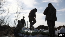 Ukrajinski vojnici gomilaju vreće sa zemljom za izgradnju utvrđenja nedaleko od grada Avdiivka, u ukrajinskoj oblasti Donjeck, usred ruske invazije na Ukrajinu, 17. februara 2024.