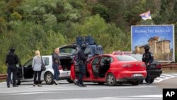 Косовските полицајци пребаруваат возила на раскрсницата што води до манастирот Бањска за време на тековната полициска операција во селото Бањска, Косово, 25 септември 2023 година.