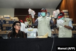 Basariah Panjaitan (Kiri), Wakil Ketua KPK, duduk bersama petugas KPK dan barang bukti berupa uang senilai lebih dari $560.000, disita dari kantor seorang anggota DPR menjelang Pemilu 2019. (Foto: AFP) ​