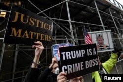 Para pengunjuk rasa berdiri di luar kantor Kejaksaan Distrik Manhattan saat penyelidikan tentang suap Donald Trump sebesar $130.000 yang dilakukan sebelum Pilpres 2016 kepada seorang bintang porno. (Foto: Reuters)