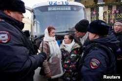 Pripadnice ženskog pokreta "Put kuči" zahtevaju vraćanje svojih muževa koji su se pridružili ruskim oružanim snagama angažovanim u vojnim operacijama u Ukrajini, stoje okružene policijom tokom okupljanja u centru Moskve, 3. februara 2024.