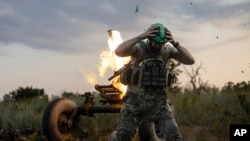 A Ukrainian serviceman of the 3rd Assault Brigade fires a 122mm mortar towards Russian positions at the front line, near Bakhmut, Donetsk region, July 2, 2023. 