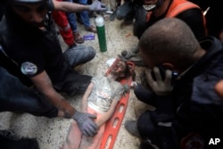 ชาวปาเลสไตน์เข้าช่วยชีวิตเด็กหญิงคนหนึ่งที่ได้รับบาดเจ็บออกจากเศษซากอาคารที่ถูกทำลาย หลังการโจมตีทางอากาศโดยอิสราเอล เข้าใส่ค่ายผู้อพยพ ข่าน ยูนิส ทางใต้ของฉนวนกาซ่า เมื่อวันที่ 7 พ.ย. 2566