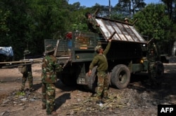 FILE - Soldiers carry belongings of a resident to a military truck at the Angkor Wat temple area in Siem Reap province, Cambodia, Jan. 16, 2023.