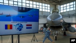 一名羅馬尼亞軍人走過停放在費泰什蒂外的一處軍事基地的機庫內的一架荷蘭皇家空軍的F-16戰鬥機。(2023年11月13日)