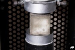 A mortar cube is tested for compressive strength in the product lab at Fortera's facility in San Jose, Calif., Wednesday, April 10, 2024. (AP Photo/Benjamin Fanjoy)