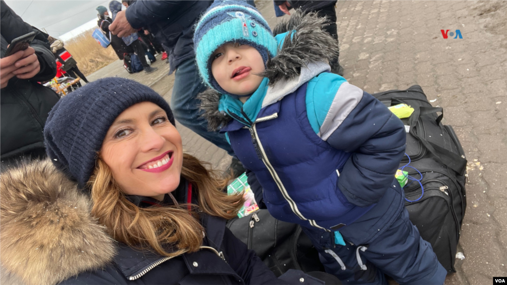 La corresponsal de la Voz de América, Celia Mendoza y un niño que escapó de Ucrania por el cruce fronterizo de Medyka, en Polonia. Esta imagen fue tomada después de entrevistar a su hermano mayor y a su papá. En Medyka, Polonia, el 9 de marzo de 2022.