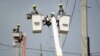 ARCHIVO - Obreros reparan cables eléctricos dañados por el huracán María en la comunidad Cantera en San Juan, Puerto Rico, el 19 de octubre del 2017. Actualmente la isla sufre de apagones crónicos en medio de advertencias de calor excesivo.