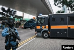 一辆香港壹传媒创办人黎智英乘坐的监狱武装车离开西九龙法院，香港警察高度戒备。（2023年12月18日）