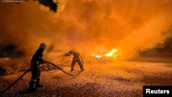 Vatrogasci gase pogođene kamione tokom ruskog napada drnovima na luku na Duvanu, u regionu Odese, Ukrajina, 26. septembra 2023.