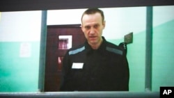 FILE - Russian opposition leader Alexey Navalny is seen on a TV screen as he appears in a video provided by the Russian Federal Penitentiary Service in Melekhovo, Vladimir region, during a hearing at the Russian Supreme Court in Moscow, June 22, 2023. 