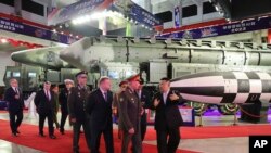 Picha imetolewa na serikali ya Korea Kaskazini, Kiongozi wa Korea Kaskazini Kim Jong Un, kulia, akiwa na ujumbe wa Russia ukiongozwa na Waziri wa Ulinzi Sergei Shoigu wakitembelea maonyesho ya silaha huko Pyongyang, Korea Kaskazini, Julai 26, 2023.