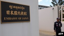 រូប​ឯកសារ៖ បុគ្គលិក​សន្តិសុខ​មួយ​ឈរ​យាម​នៅ​មុខ​ស្ថានទូត​ជប៉ុន​ក្នុង​រាជធានី​ភ្នំពេញ​កាល​ពី​ថ្ងៃ​ទី​១៨ ខែមីនា ឆ្នាំ២០១១។ តបតាម​សំណើ​របស់​ស្ថានទូត​ជប៉ុន​ ប៉ូលិស​កម្ពូជា​​បាន​ឃាត់​ខ្លួន​ជន​ជាតិ​ជប៉ុន​ចំនួន​២០​នាក់​​សាក​សួរ។