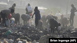 People look for recyclable materials for a living, at Dandora, the largest garbage dump in the capital Nairobi, Kenya Wednesday, March 20, 2024. U.N. agencies have warned that electrical and electronic waste is piling up worldwide. (AP Photo/Brian Inganga)