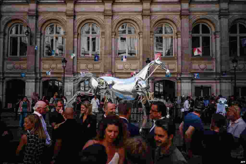 Visitors attend the inauguration of displaying Zeus, the metal horse of the Paris 2024 Olympic Games' opening ceremony, at the Hotel de Ville's courtyard in Paris, France.