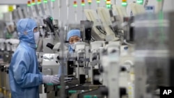 Zaposleni koji nose zaštitnu opremu rade u pogonu za proizvodnju poluprovodnika za Renesas Electronics u Pekingu, Kina, 14. maja 2020.