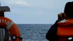A Taiwanese navy sailor on the Cheng Kung-class guided-missile Tien Dan frigate monitors the Chinese navy ship Xuzhou-class off the Taiwan coast on Aug. 19, 2023, in this grab from video released by the Taiwan Ministry of National Defence.