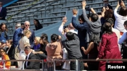 លោក​ប្រធានាធិបតី Joe Biden គ្រវីដៃ​ពេល​មនុស្សម្នា​ថត​រូប​លោកនិង​គ្រួសារ​របស់​លោក ពេល​ចូលរួម​ក្នុង​ពិធី​បញ្ចប់​ការសិក្សា​នៅ​សាកល​វិទ្យាល័យ Pennsylvania ដែល​ចៅស្រី​របស់​លោក គឺ​នាង Maisy Biden ទទួល​សញ្ញាបត្រ​នៅ​ទីក្រុង Philadelphia ថ្ងៃទី១៥ ខែឧសភា ឆ្នាំ២០២៣។