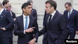 El presidente francés, Emmanuel Macron, y el primer ministro británico, Rishi Sunak, hablan después de una foto grupal con los ministros durante una cumbre franco-británica en el Palacio del Elíseo en París, Francia, el viernes 10 de marzo de 2023.