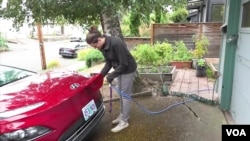 รีเบคกา เดอวิทท์ เจ้าของรถยนต์ไฟฟ้า ขณะชาร์จไฟรถที่บ้าน