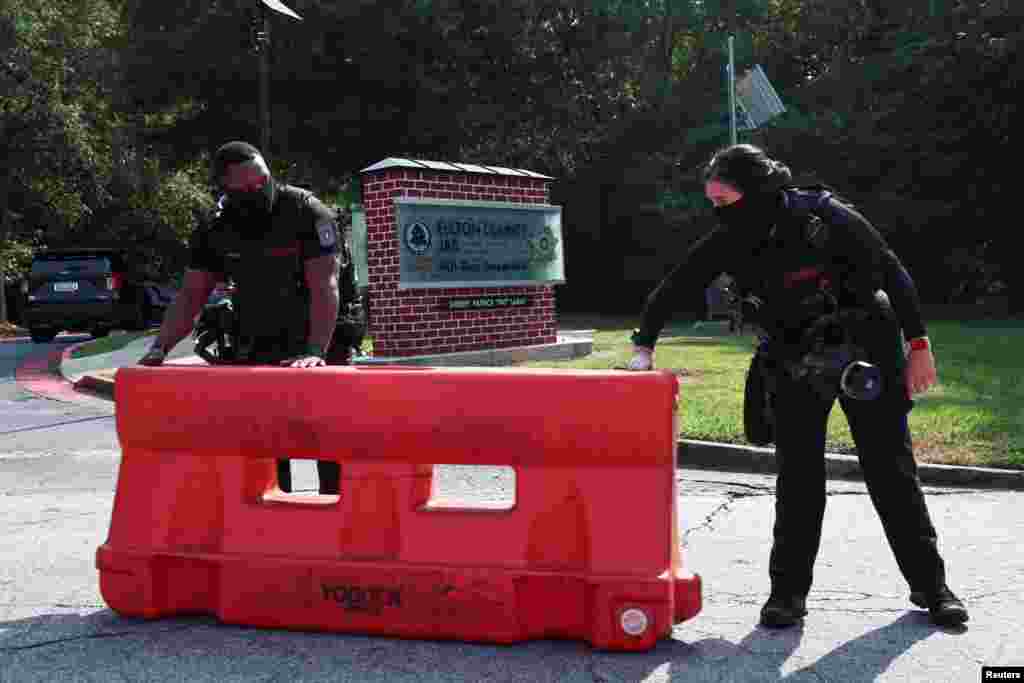 មន្ត្រី​សន្តិសុខ​ដាក់​របាំង​ការពារ​នៅ​ខាង​ក្រៅ​ពន្ធនាគារ​​ស្រុក Fulton ក្រុង Atlanta រដ្ឋ Georgia មុន​ការ​មក​ដល់​របស់​លោក​អតីត​ប្រធានធិបតី​អាមេរិក Donald Trump កាល​ពី​​ថ្ងៃ​ទី​២៤ ខែ​សីហា ឆ្នាំ ២០២៣។