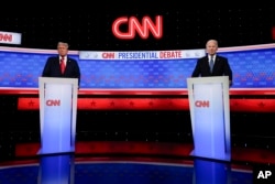 Presiden Joe Biden, kanan, dan calon presiden dari Partai Republik mantan Presiden Donald Trump, kiri, berdiri saat istirahat dalam debat presiden yang diselenggarakan oleh CNN di Atlanta, Georgia, 27 Juni 2024. (Foto: AP)