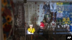 Prodavačica sa baterijskom lampom tokom nestanka struje u podzemnom tržnom centru u centru Kijeva, Ukrajina, 19. juna 2024.