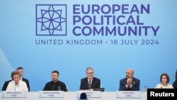 Britain's Prime Minister Keir Starmer speaks at the opening of the European Political Community meeting at Blenheim Palace in Woodstock, Britain, July 18, 2024. Seated to Starmer's left is Ukrainian President Volodymyr Zelenskyy.