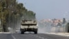 Israeli tanks drive on a road near Sderot in southern Israel, following a mass infiltration by Hamas gunmen from the Gaza Strip, Oct. 8, 2023. 