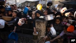 Warga Palestina mengantre untuk mendapatkan makanan gratis di Rafah, Jalur Gaza, pada Selasa, 12 Maret 2024. (Foto: AP/Fatima Shbair)