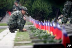 Soldiers salute to the fallen during a ceremony commemorating the 65th anniversary of deadly attack by China on Kinmen island, in Kinmen, Taiwan, Aug. 23, 2023.