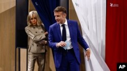 Francuski predsjednik Emmanuel Macron i njegova supruga Brigitte Macron napuštaju glasačku kabinu prilikom glasanja u Le Touquet-Paris-Plage, sjeverna Francuska, 30. juna 2024.