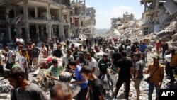 Palestinos cargan algunas pertenencias rescatadas cuando salen del campo de refugiados de Jabalia, en el norte de la Franja de Gaza, después de regresar brevemente para ver cómo estaban sus hogares el 30 de mayo de 2024.