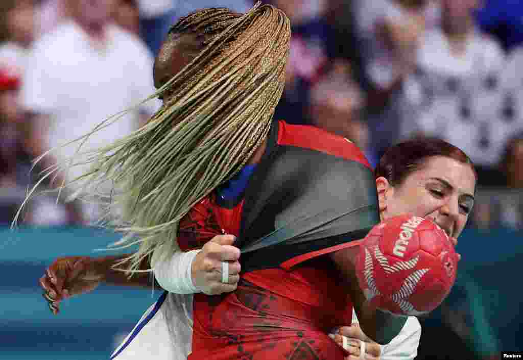Azenaide Carlos of Angola tackles with Tamara Horacek of France during the 2024 Summer Olympics women's handball preliminary round group B match at the South Paris Arena 6 in Paris, France.