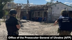 In this handout photograph taken and released by the Office of the Prosecutor General of Ukraine on Aug. 26, 2023, war crime prosecutors work at the site of a shelling in the village of Podoly near Kupiansk, Kharkiv region.