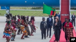 U.S. Vice President Kamala Harris, second right, is greeted by traditional dancers after landing in Lusaka, Zambia, March 31, 2023.